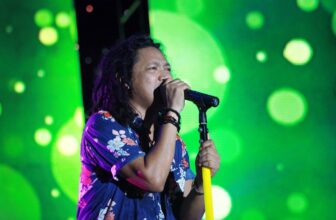Singer holding a microphone at a reggae concert