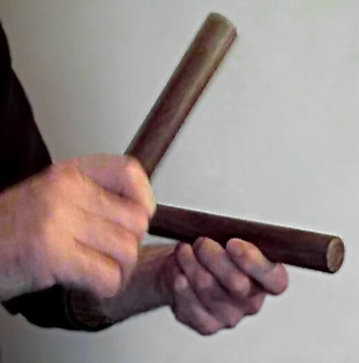 A pair of wooden claves held in playing position